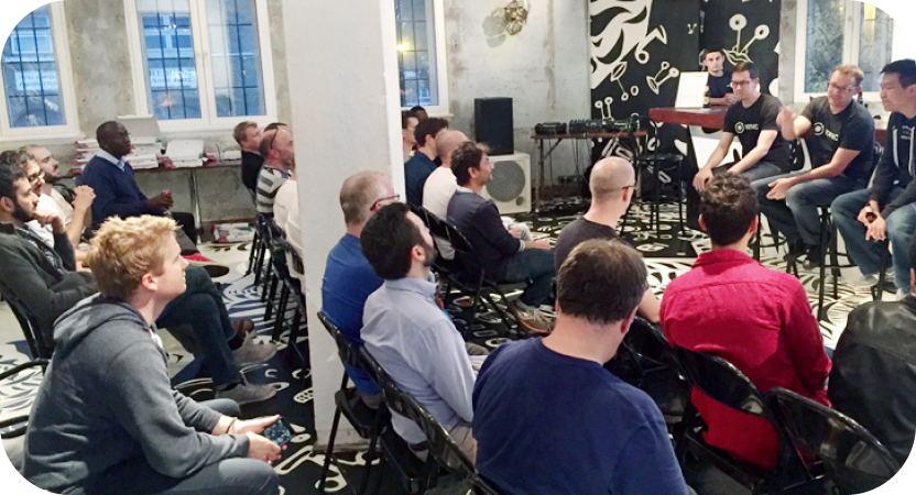 Crowded room of people watching a presentation from a panel