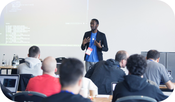 Several people watching a presentation from a conference speaker