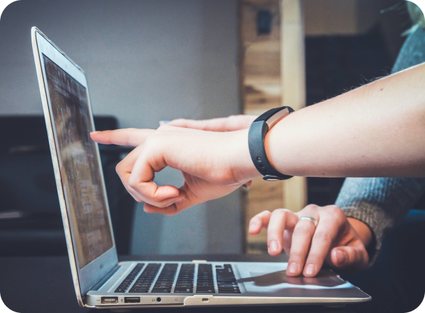 people pointing at laptop