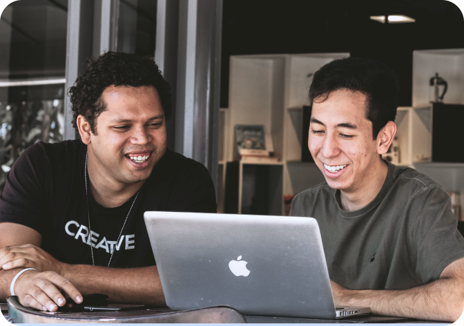 two people looking at macbook